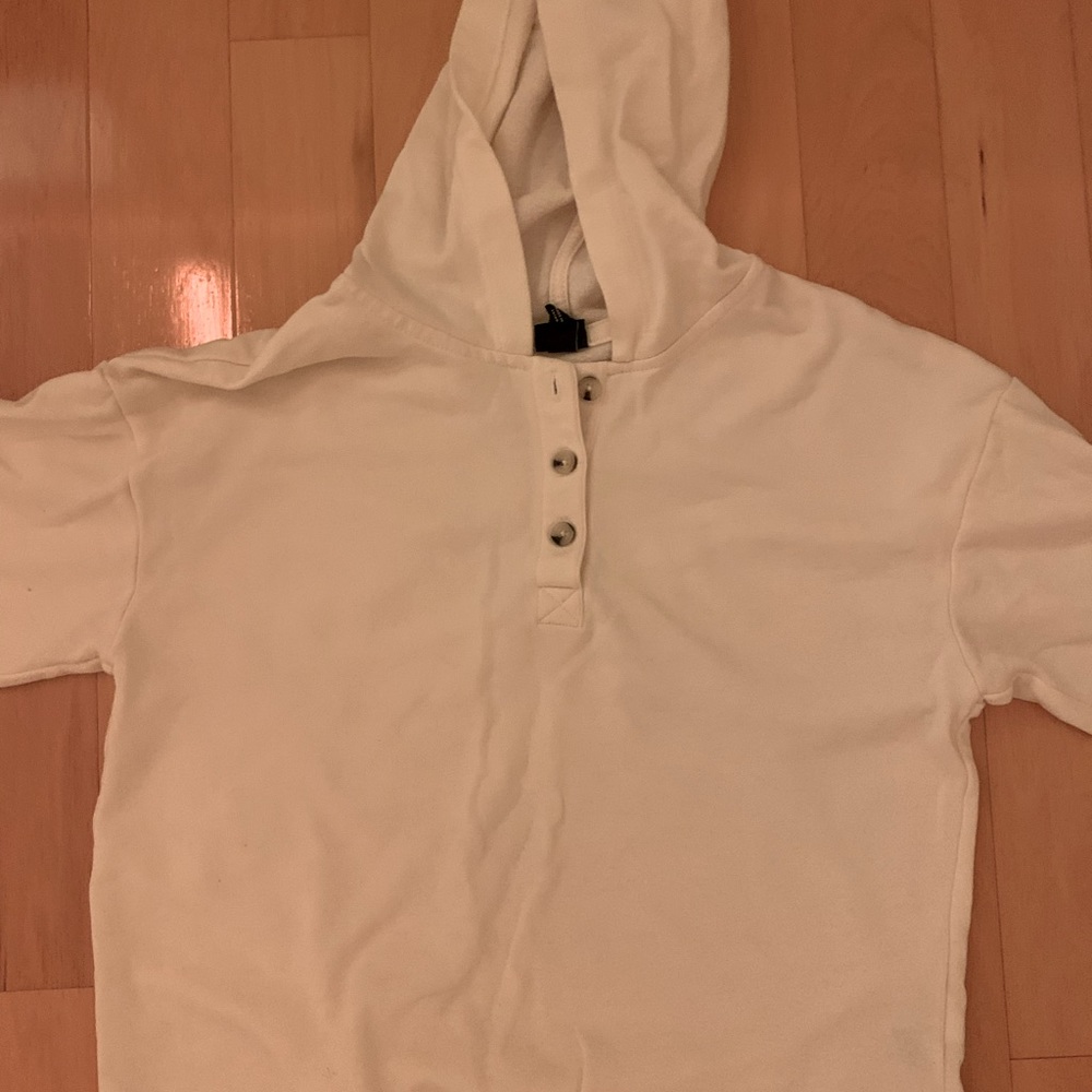 White hooded sweater with wooden buttons.
